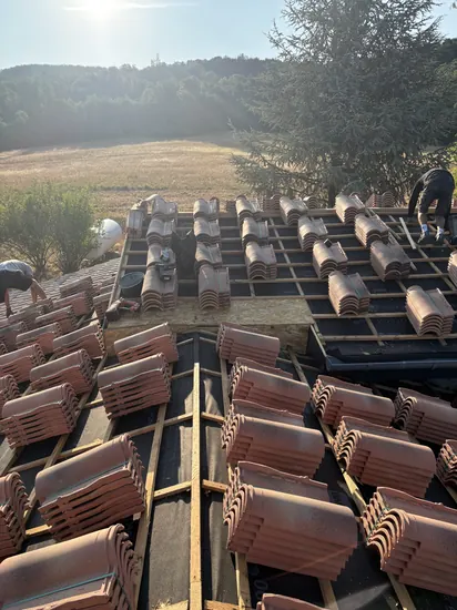 Chantier de couverture en cours, l'équipe C. HABITAT répartit les tuiles sur les liteaux