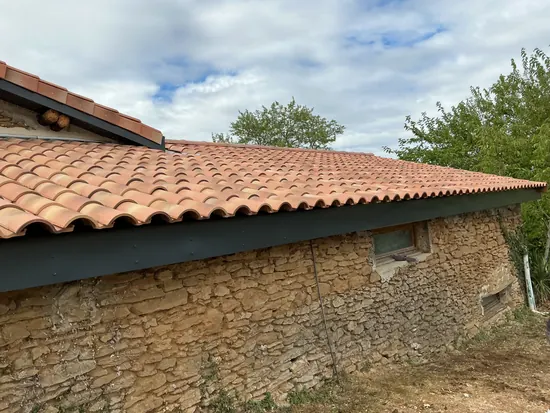 Couverture tuiles neuves et gouttière sur long mur en pierre - C. HABITAT
