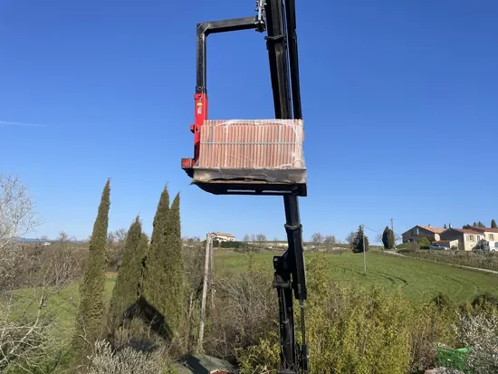 Livraison des palettes de tuiles par grue sur un chantier - C. HABITAT